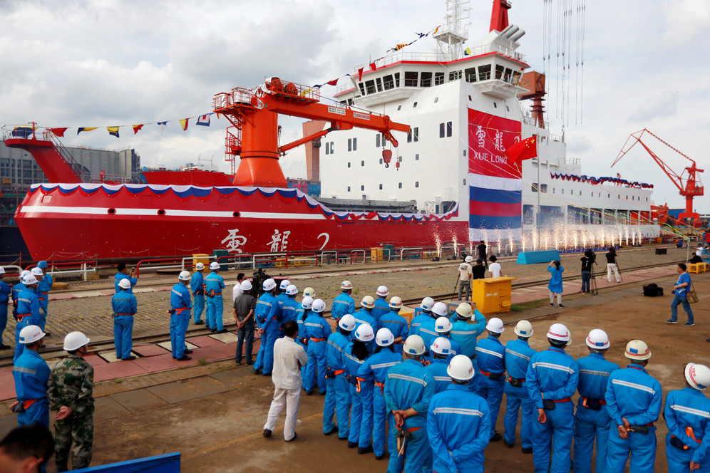 People standing on dock alongside China's first polar icebreaker at launch ceremony in Shanghai, China